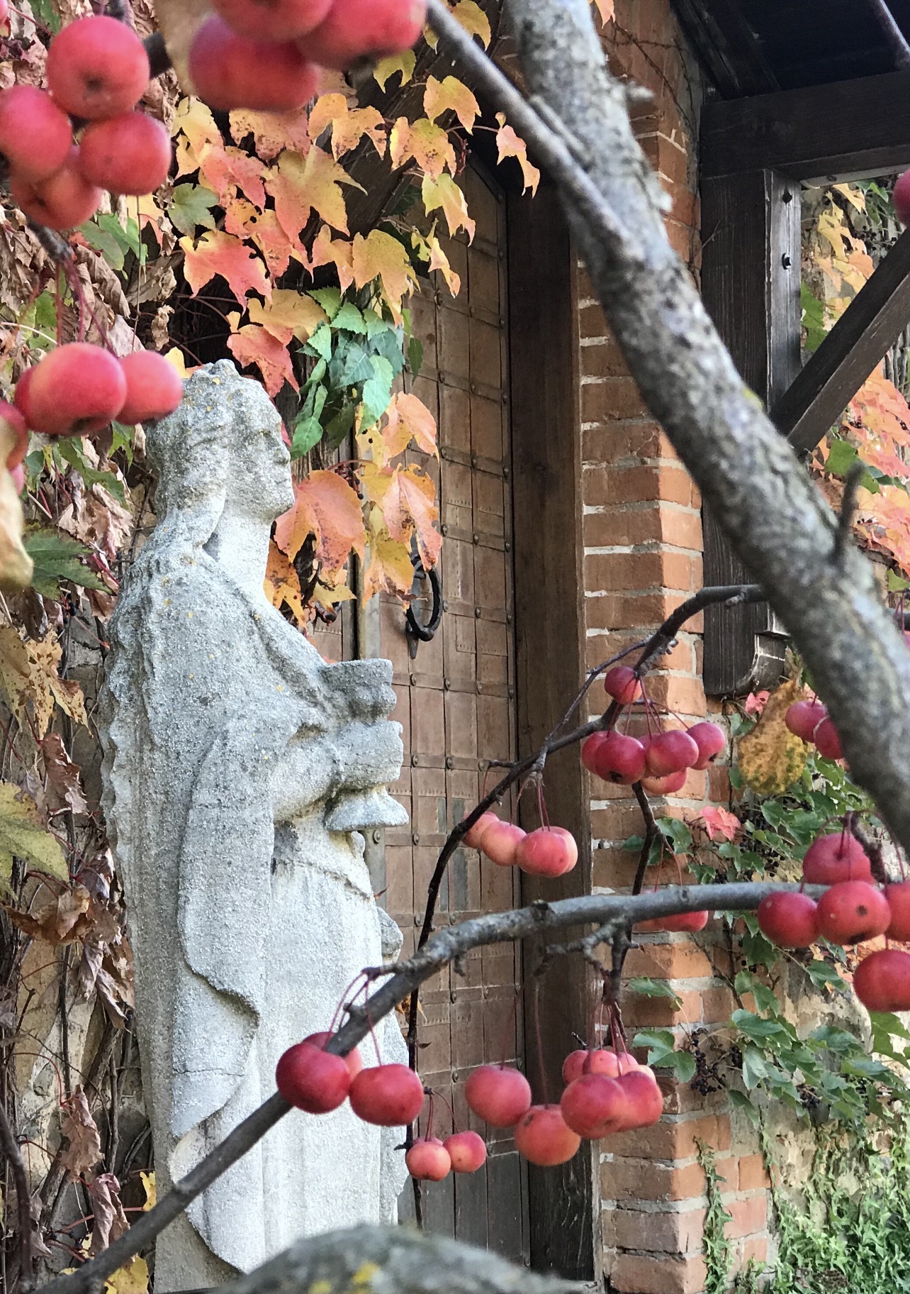 Stone figure among apples in the castle’s autumn garden